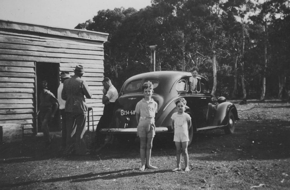 Group of men and children standing near a car at Donnybrook, ca. 1940s