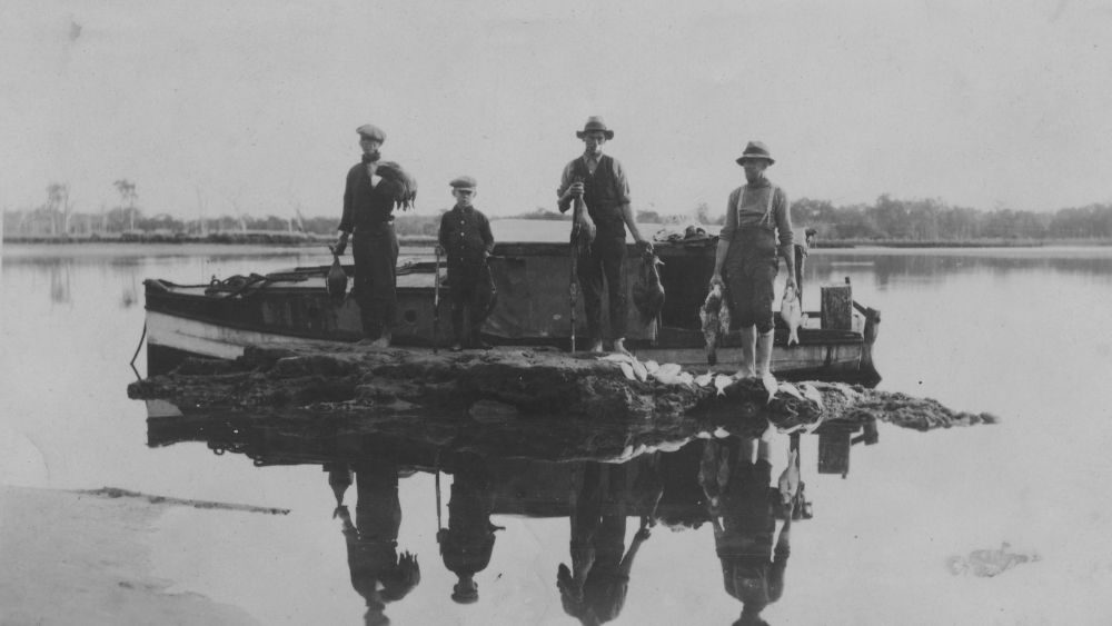 A group of men and a boy that have returned from fishing and duck hunting