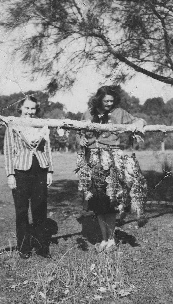 Olivine Garland standing near fish hanging on a pole at Donnybrook, ca. early 1940s