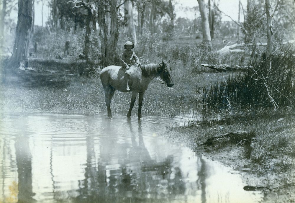 Wilbraham Hulme on a horse near a creek