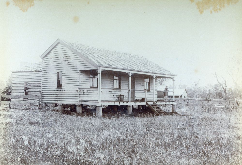 Small house with buildings and fenced paddocks