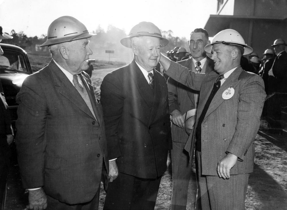 Three men in suits wearing hard hats