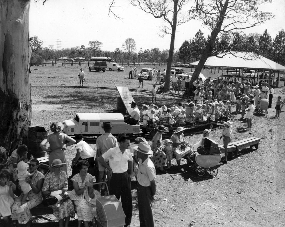 Children enjoying train rides at the Christmas party, 1957