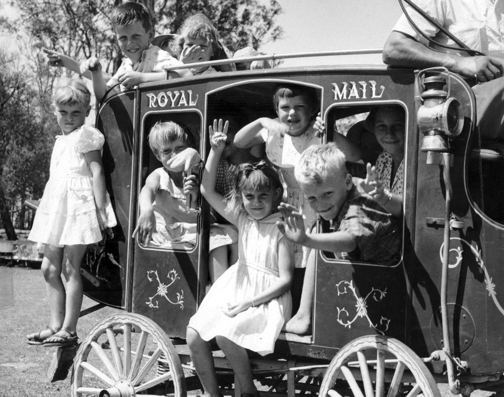 Children enjoying a ride on a replica Royal Mail coach at the Christmas party, 1957