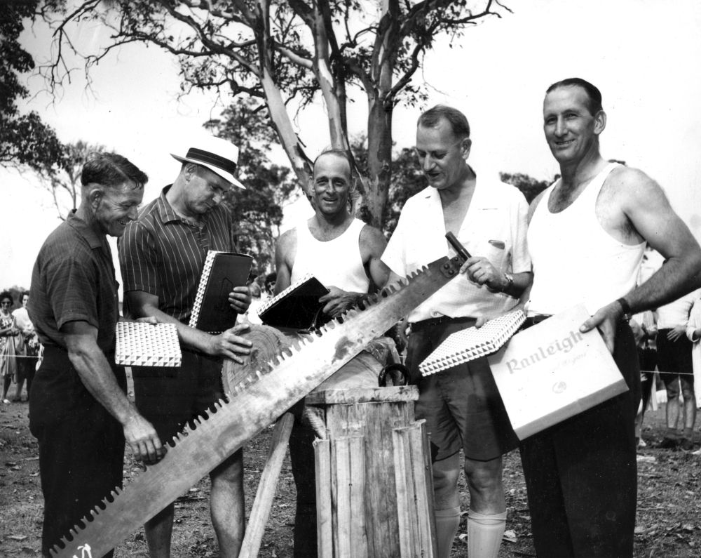 Men with a crosscut saw at a Christmas party sports event