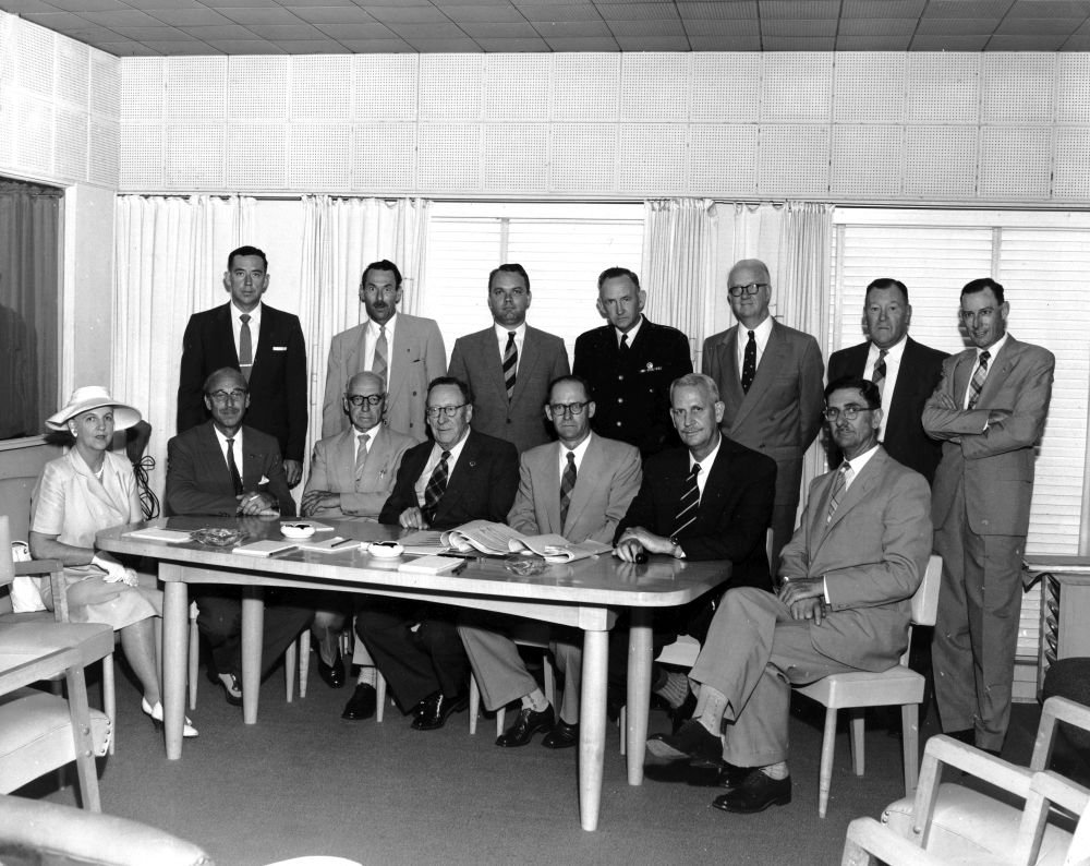 Group of men and a woman attend a meeting
