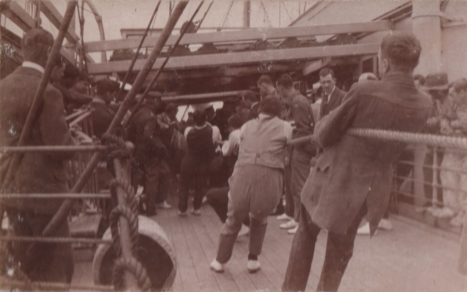 A group of men play tug-of-war on a boat