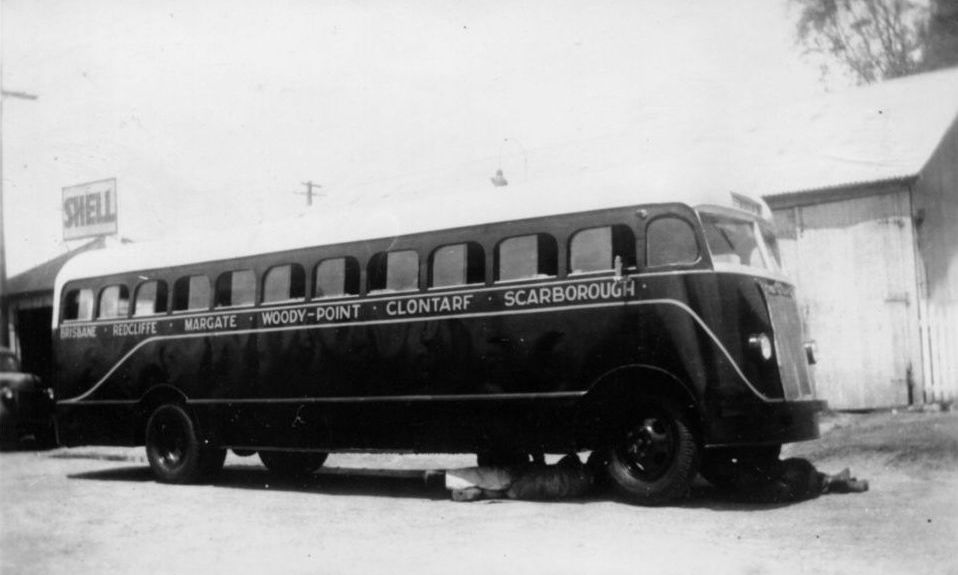 Mechanics working underneath the front of a bus
