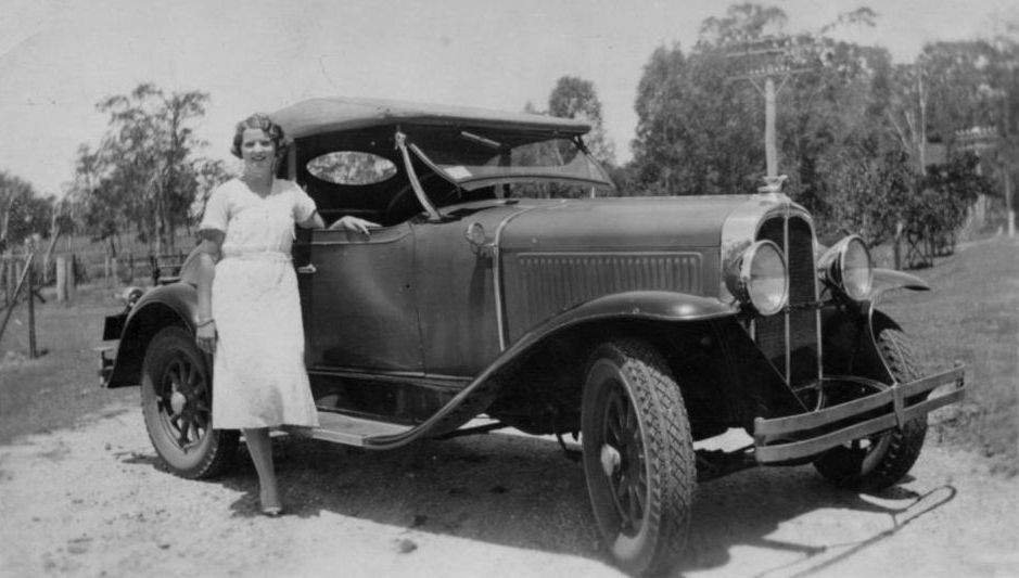 Elva Elson standing next to a car