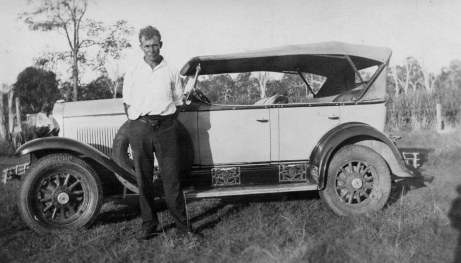 Unknown man standing next to car