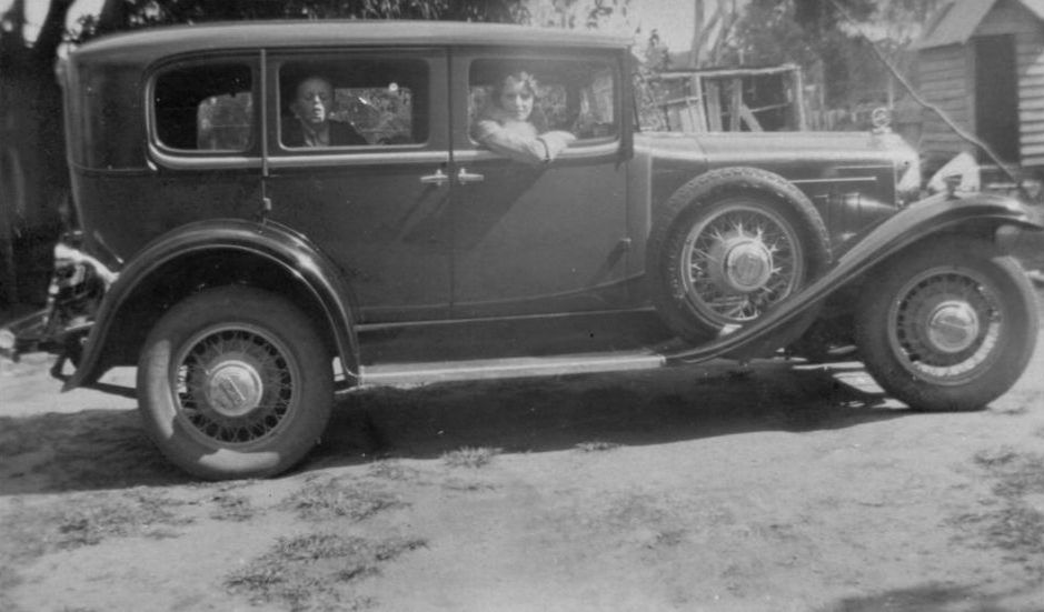 Elva Elson sitting in driver's seat of car with young boy sitting in the back