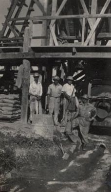 Four men wearing hard hats working on drainage