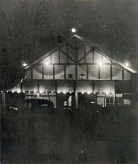 Woodford Theatre lit up at night before reticulation electricity came to town