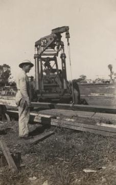 Crane lifting beams - Worker in foreground