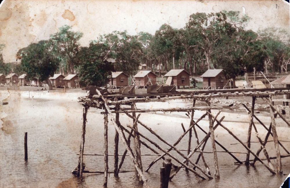 12 one room huts line the foreshore at Bongaree in 1923