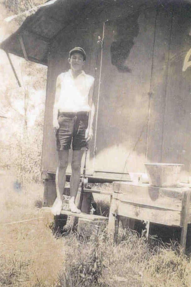 Colin Sinclair standing beside holiday cottage on Bribie Island
