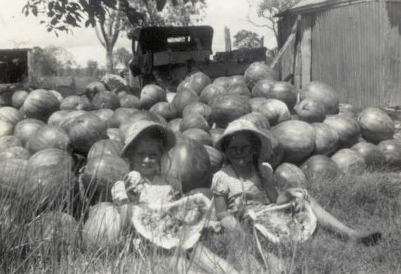 Joan (left) and Carole (right) Lehman playing amongst some of the watermelons from their parents' farm in the 1940s