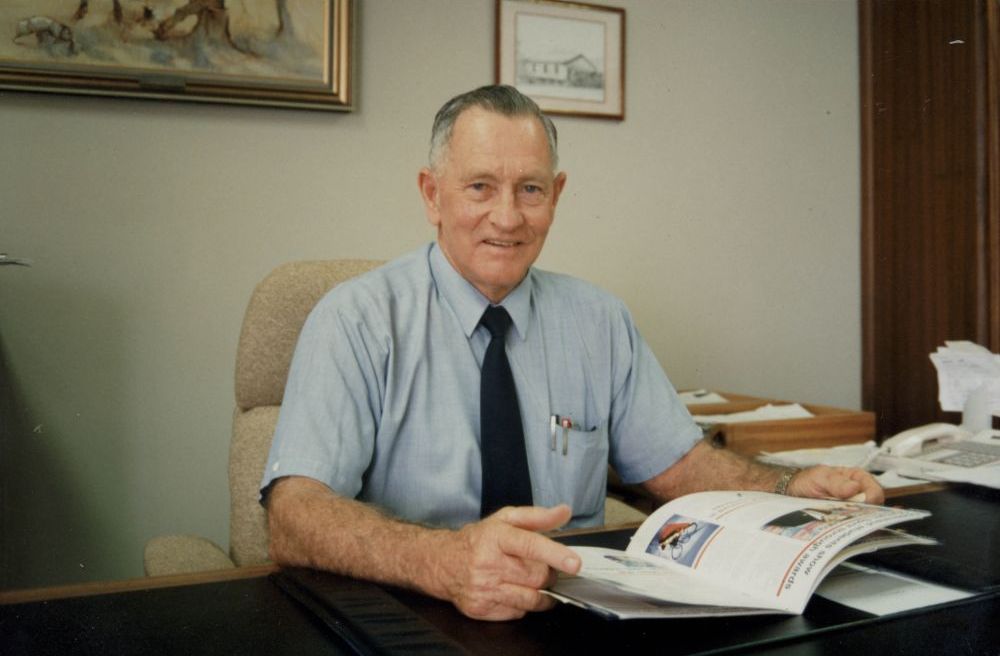 Cr J.T. (Tom) McLoughlin sitting at his desk in the Mayor's office