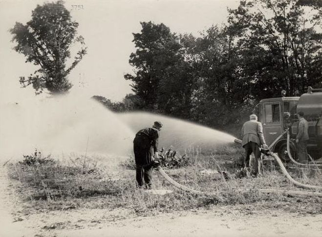 2 Men using hoses connected to the Foden Fire Truck