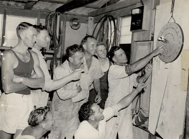 8 Male Workers playing darts