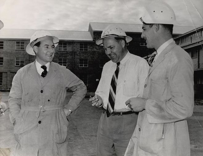 3 Men in front of Mill Buildings