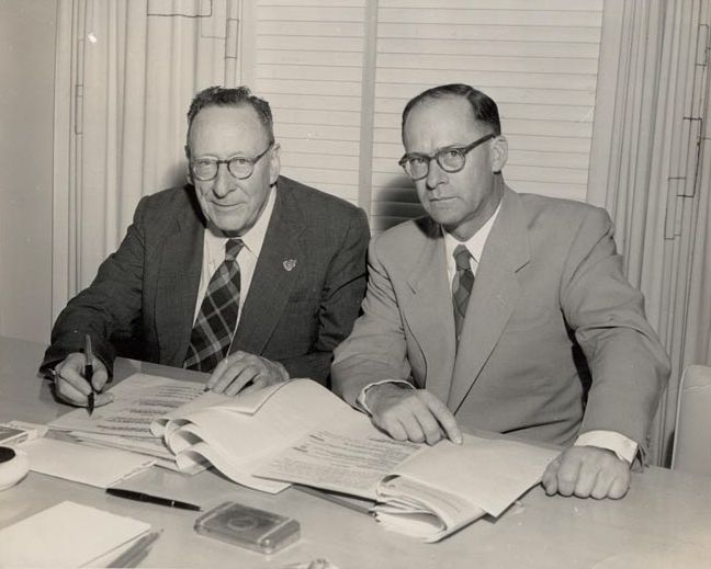 2 Men at desk signing paperwork