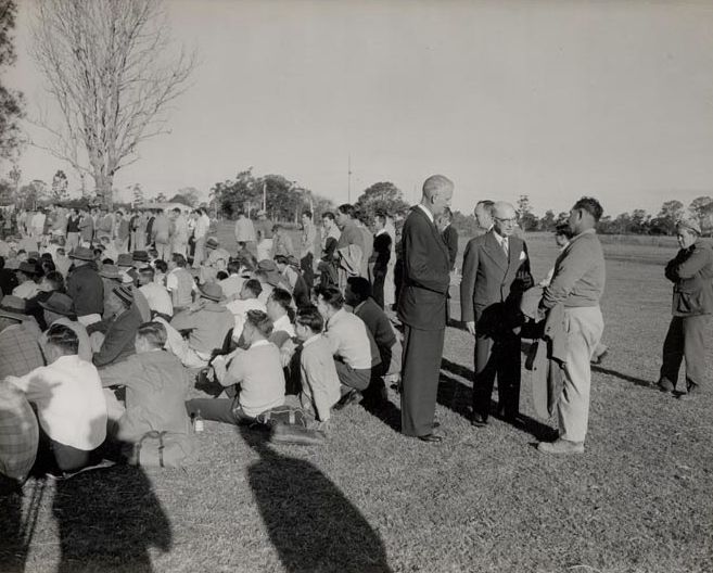 Workers sitting on grass in front of Mill