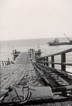 Looking down wharf towards approaching boat