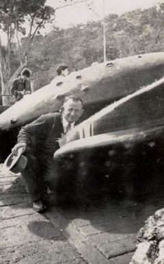 Man kneeling near whale carcass