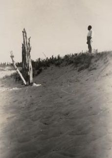 Man standing on top of sand dune