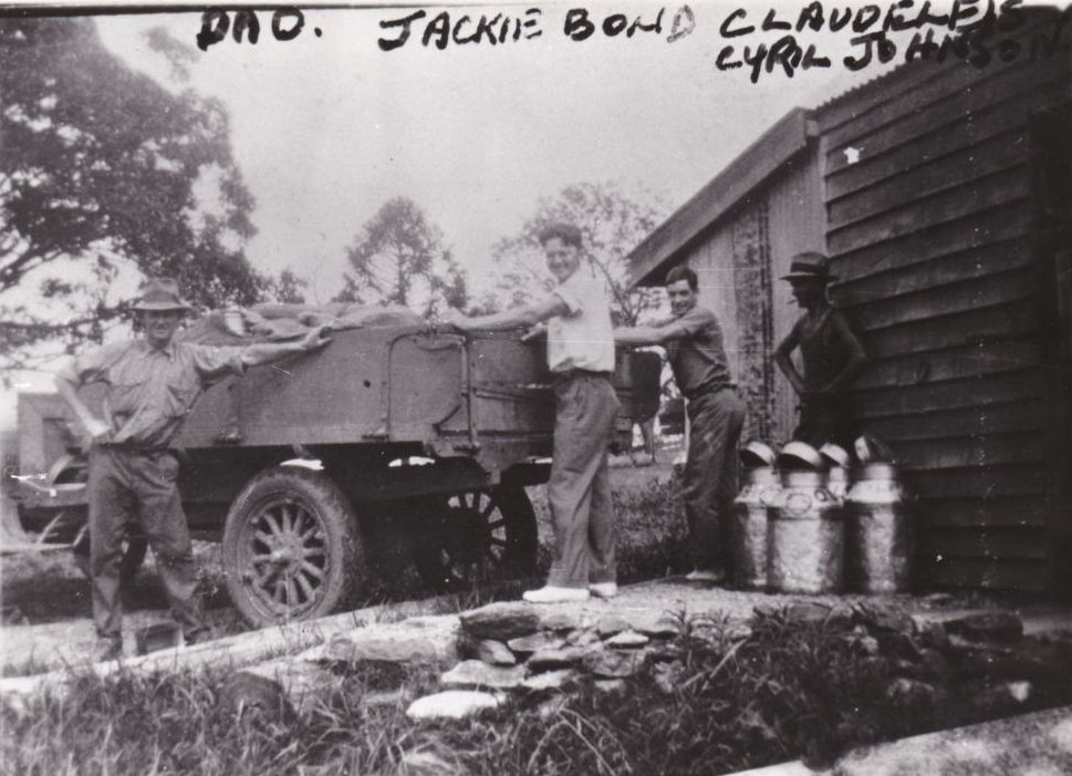Loading milk cans onto the back of a truck, ca. 1920
