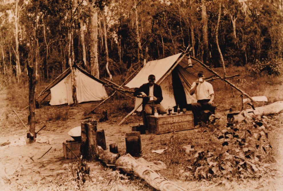 Two men sitting in front of their camp tent