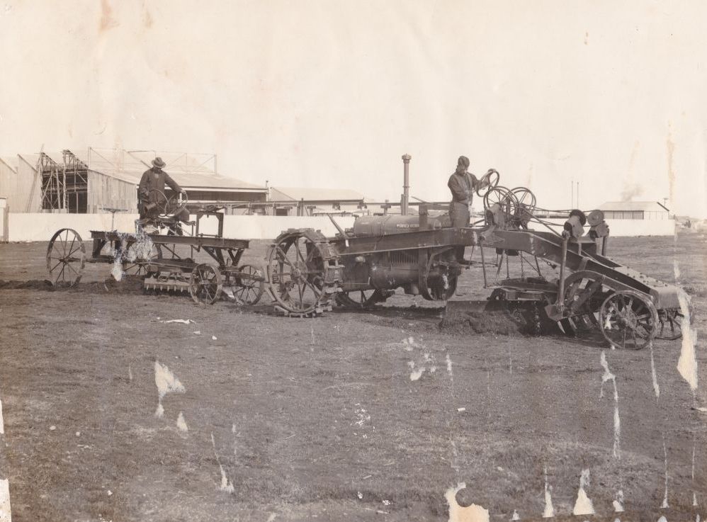 Two men driving and operating graders, ca. 1930
