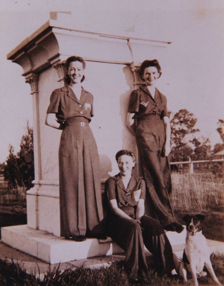 Three women and a dog at the second site of the Tom Petrie Memorial, Petrie, early 1940s.