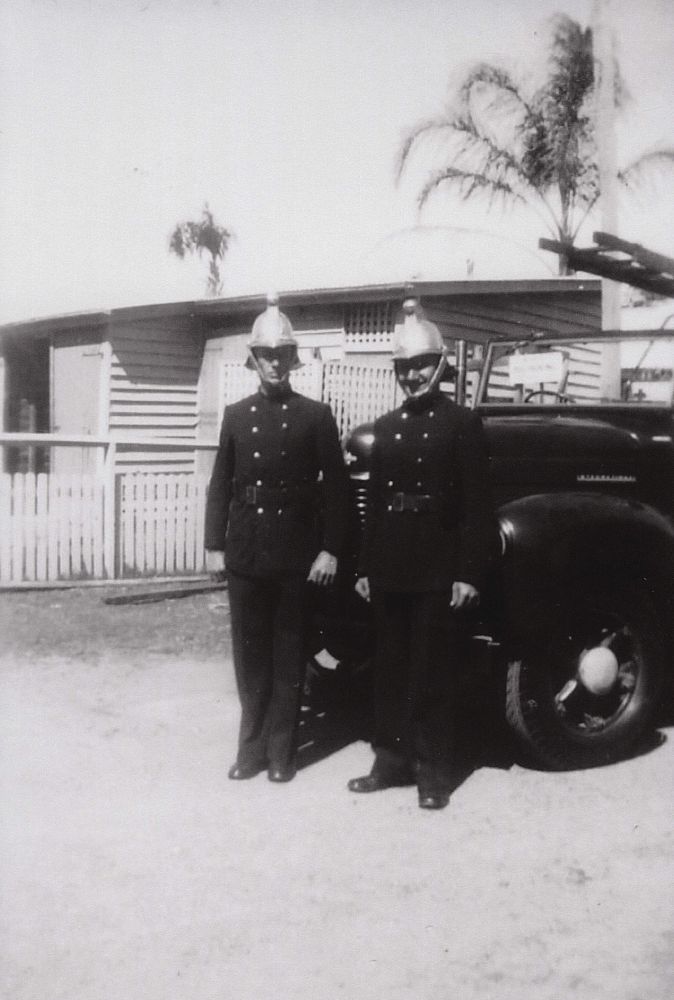 Two firefighters standing in front of fire truck