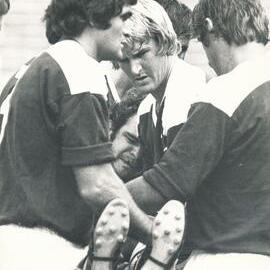 Injured player being carried from field by Vic Tighe
