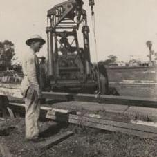 Crane lifting beams - Worker in foreground