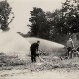 2 Men using hoses connected to the Foden Fire Truck