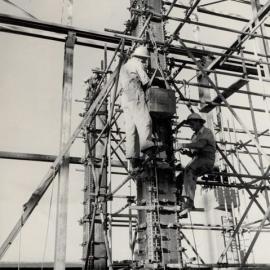 2 Workers up a metal pylon working